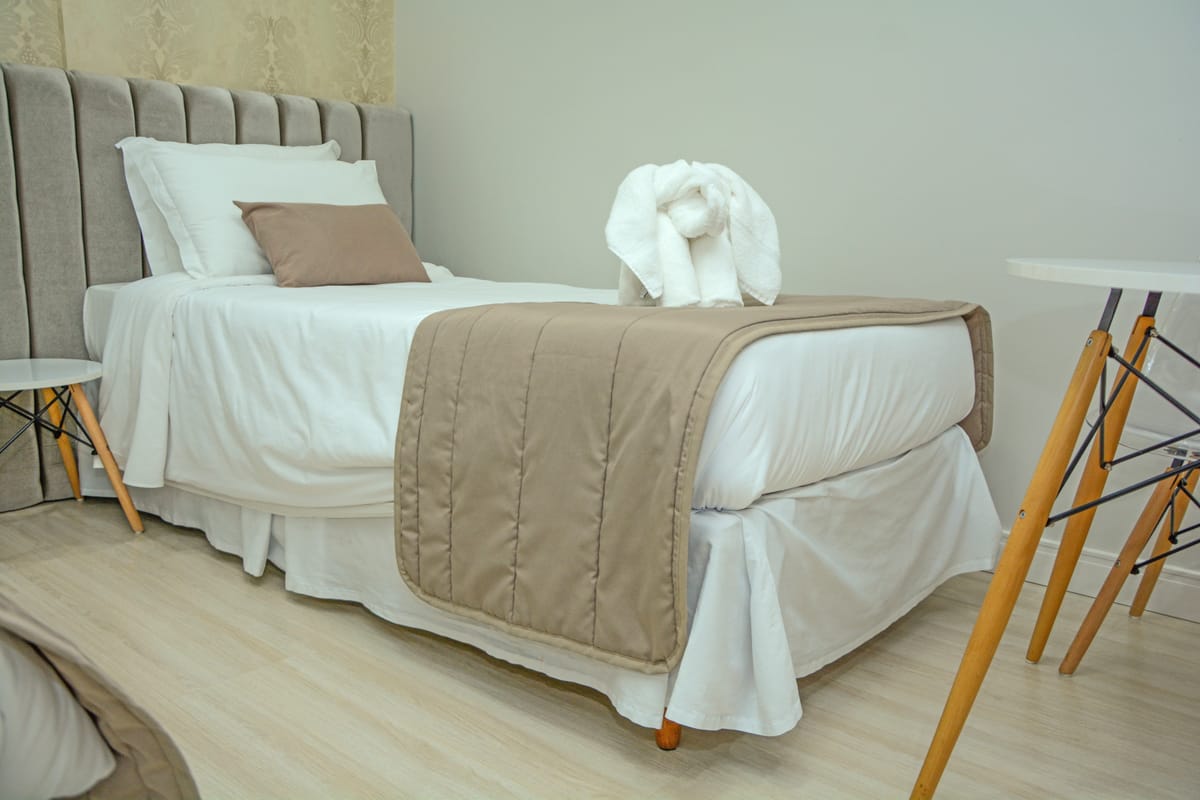 Apartamento do Hotel Rouxinol com camas de solteiro e toalha decorada