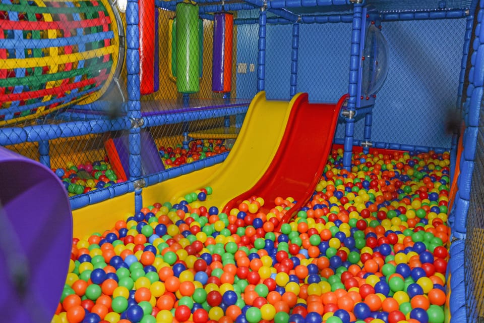 Espaço kids do Hotel Rouxinol com piscina de bolinhas e escorregador