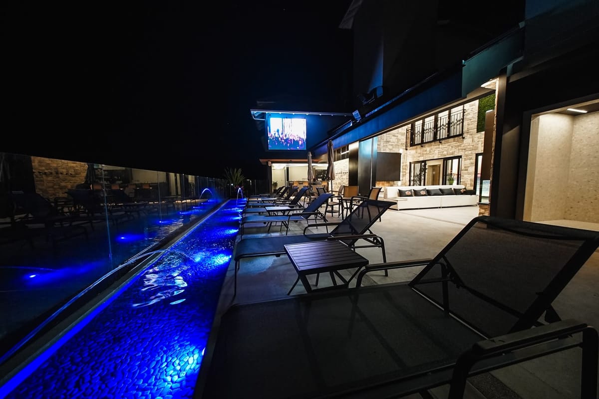 Piscina do Hotel Rouxinol iluminada à noite, com a água em tom azul