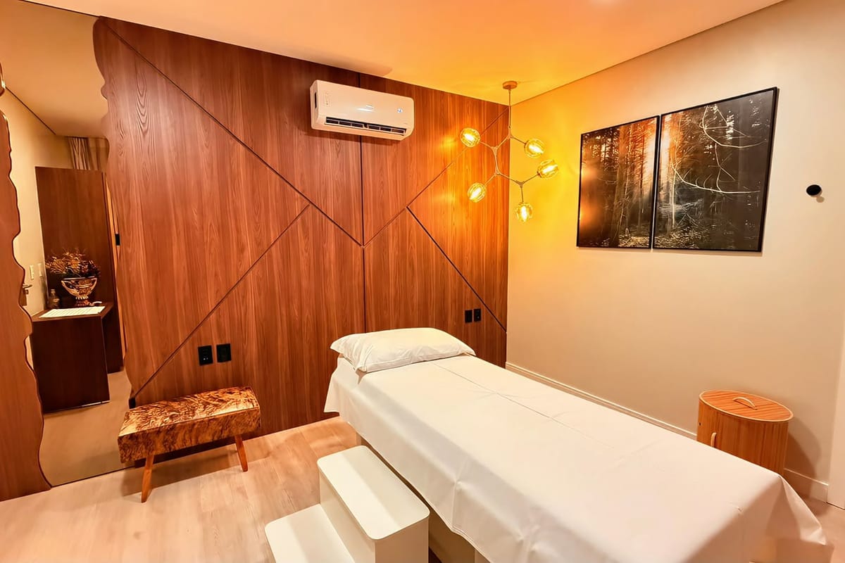 Sala de massagem do Hotel Rouxinol, com painel de madeira, maca e luz ambiente