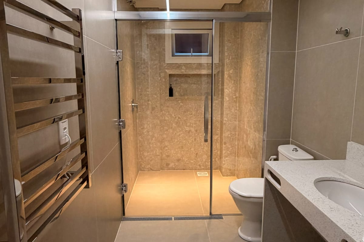 Banheiro do apartamento Superior, com box de piso a teto e toalheiro elétrico