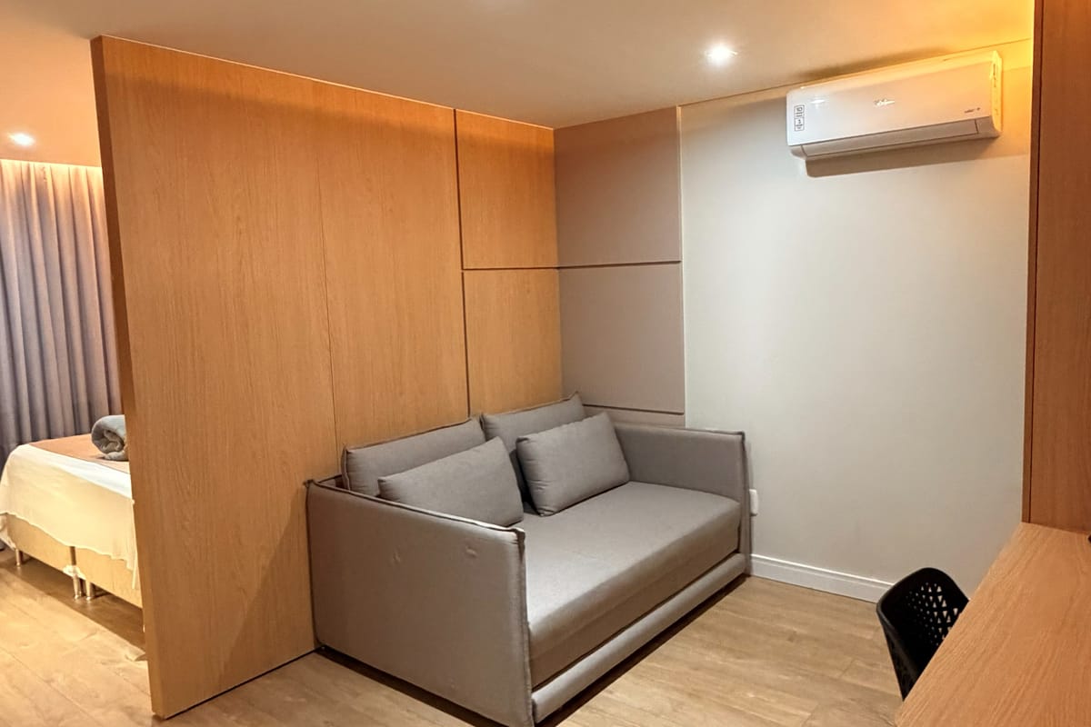 Sofá cama do apartamento Superior, separado da cama por uma divisória de madeira